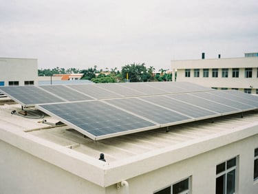 Medium shot of solar panel arrays installed on a community clinic roof, natural bright overcast daylight, desaturated organic tones, honest documentary photography.