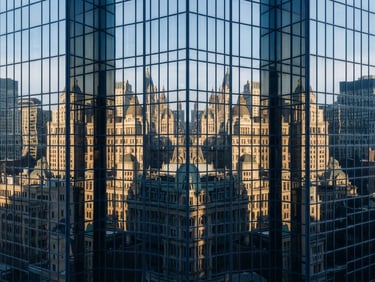 Abstract geometric reflection on a glass skyscraper facade, clean symmetrical lines, cool daylight, high-contrast architectural editorial