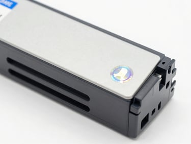 Macro shot of a sealed OEM printer cartridge box with a holographic authenticity seal, clean white background, sharp focus.