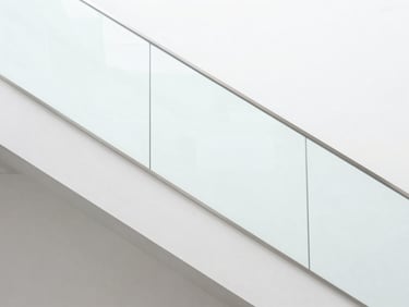 Minimalist luxury staircase with structural glass railing, clean lines, bright architectural photography