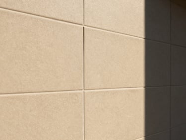 Close-up of perfectly aligned premium ceramic tiling on a wall, warm sand tones, sharp details, bright natural daylight, interior architecture, 35mm