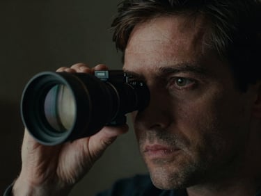 Extreme close-up of a film director looking intensely through an anamorphic viewfinder, low-key lighting, high contrast, 35mm grain