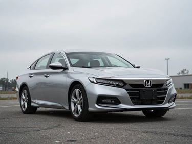2021 Honda Accord sedan, silver, parked on an open lot under overcast light, three-quarter front view, documentary style