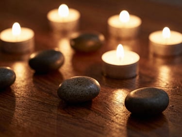 Warm basalt stones resting on dark polished wood, soft golden candlelight reflecting on premium massage oil, shallow depth of field, 35mm
