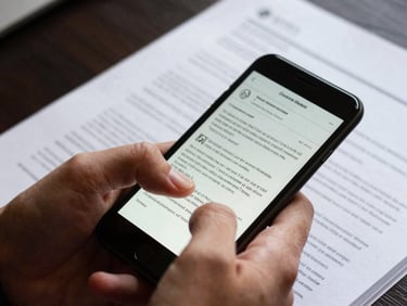 Close-up of a hand holding a smartphone, scrolling through a digital brief document, high-contrast natural light, vibrant editorial photography, tight crop.
