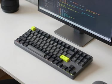 Overhead desk setup with a mechanical keyboard and a high-resolution screen showing clean code, cool-toned lighting.