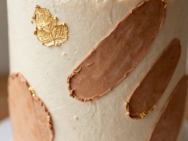 Close-up of an abstract sculpted celebration cake with gold leaf accents, warm side-lighting, shallow depth of field, 35mm