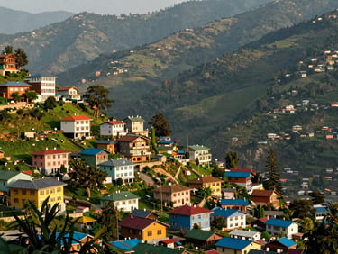 Stunning view of Gangtok valley from a high altitude viewpoint, colorful buildings nestled in green mountains, bright natural daylight, professional travel photography