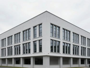 Clean, modern commercial building foundation with precise architectural lines, bright overcast daylight, cool desaturated tones.