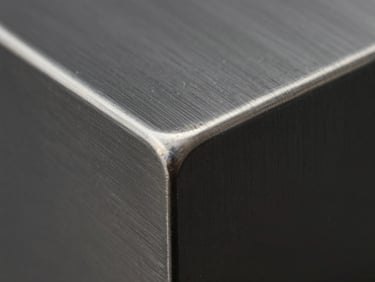 Extreme close-up macro shot of a freshly waterjet-cut stainless steel edge, showing zero heat discoloration and a clean separation line, bright neutral studio lighting, matte dark steel surface, 1:1 scale detail