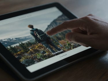 A close-up of a hand clicking a 'Download' button on a tablet screen, showing a crisp, high-resolution image in the background, natural light.