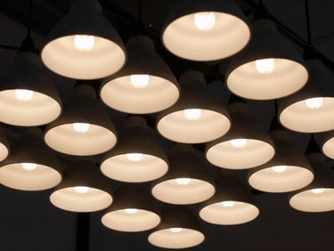 Detail shot of integrated lighting fixtures within an exhibition stand, casting dramatic shadows and warm glows, high-contrast, sharp focus, 35mm format
