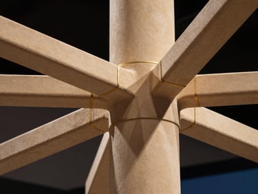 Close-up of intricate structural joints on a high-tech exhibition stand, dramatic lighting, sharp focus, sand-gold accents.