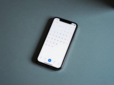 Top-down flat lay of a minimalist desk with a dark titanium phone showing a distraction-free calendar interface, sharp cool cyan shadows, 35mm