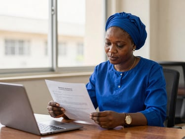 Editorial documentary photography of a focused Nigerian scholar reviewing an admission letter in a bright, modern university office, natural window light, 35mm.