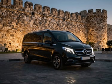 Gleaming black Mercedes Vito parked elegantly near the ancient city walls of Famagusta at dusk, low-key dramatic lighting, gold reflections, luxury automotive photography, 35mm.