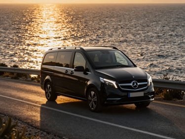 Gleaming black Mercedes Vito driving along the scenic coastal road of Kyrenia at golden hour, low-key dramatic lighting, gold reflections, luxury automotive photography, 35mm.