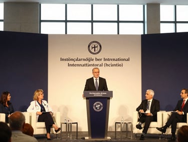 A wide environmental shot of a prestigious international medical congress panel, with Dr. Öğretmenoğlu presenting behind a sleek dark podium under warm spotlights.