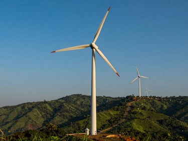 Industrial wind turbines standing in a high-wind mountain pass in Tenkasi, dramatic golden hour light