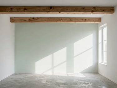 Minimalist environmental shot of a residential interior in Paris, raw timber beams, concrete floor, large window casting geometric shadows on white walls, soft overcast daylight.