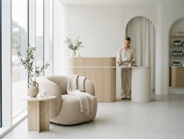 Bright editorial photography of a minimalist luxury medical spa lobby, clean clinical daylight, soft desaturated tones, shallow depth of field, 35mm