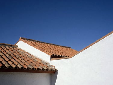 Oil painting of traditional terracotta roofs and clean geometric architectural lines of southern Spain under a deep indigo sky, styled in a bright modern interior.