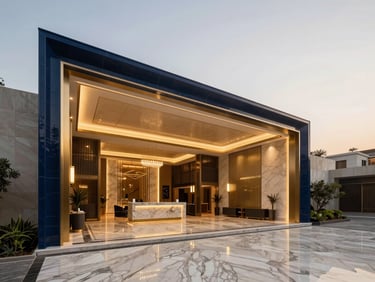Elegant modern luxury residential lobby in Gurgaon, warm champagne gold and deep navy tones, high-end marble floors, architectural lighting.