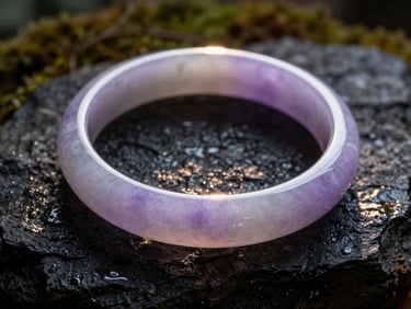 Macro photograph of a rare lavender jade bangle, smooth and translucent, catching a sliver of warm sunlight against a dark mossy background