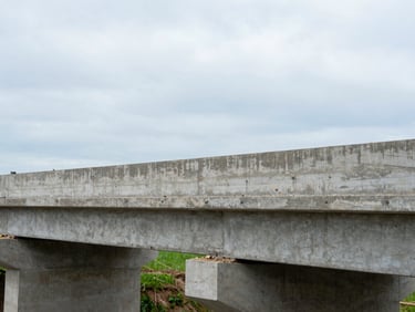 Close-up of concrete foundation work on a rural community bridge, natural overcast daylight, realistic texture