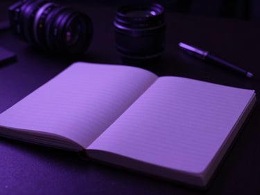 Un cahier de notes de réalisateur sur une table de montage sombre avec des lumières violettes, un stylo à côté, mise au point peu profonde, ambiance cinématographique.