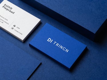 Flat-lay of premium business cards and branding materials on a dark royal blue textured surface, sharp focus