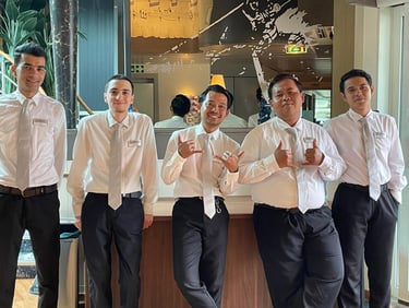 housekeeping attendants in white shirts and silver ties posing with friendly gestures.