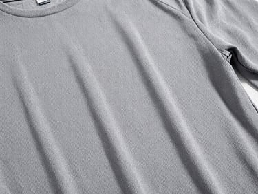 Detalle de una playera deportiva técnica con tejido transpirable microperforado, color gris pizarra, enfoque nítido en las fibras, luz brillante, 35mm.