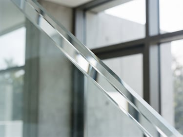 Crisp architectural close-up of a diamond-polished beveled glass edge, reflecting bright natural daylight, clean lines, high-contrast minimalist aesthetic, 35mm