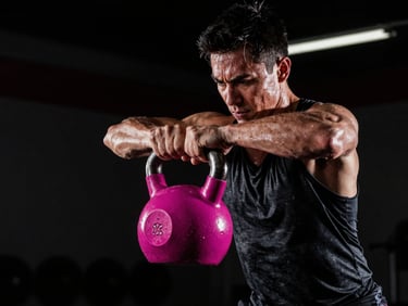 Athlete lifting a heavy kettlebell, high contrast dramatic lighting, sweat on skin, intense focus, athletic sportswear style