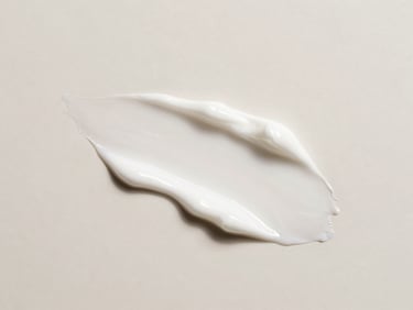 A luxurious swatch of white cosmetic cream with elegant ridges, top-down flat lay, bright diffused daylight, clean clinical photography