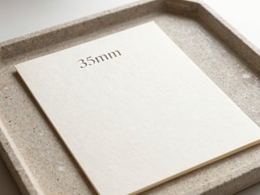 Top-down macro shot of a clean stationery mockup with elegant serif typography pressed into thick cotton paper on a textured stone tray, soft side light, 35mm