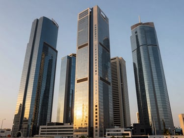 Wide environmental shot of modern corporate skyscraper architecture in Jeddah during golden hour, reflecting warm sunlight, clean lines, professional prestige