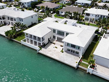 High-altitude drone photograph of a luxury waterfront estate in Tampa Bay, clear turquoise water, geometric property boundaries