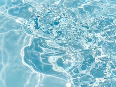 Sharp macro shot of clear water ripples on a sparkling pool surface, bright midday Florida sunlight, 35mm