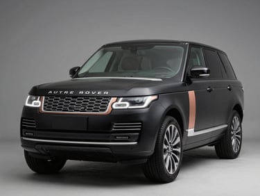 Front three-quarter view of a satin black Range Rover Autobiography, dramatic studio lighting highlighting the copper accents.