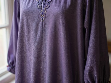 Close-up of a festive party wear garment, shimmering fabric, detailed embroidery, soft natural window light.