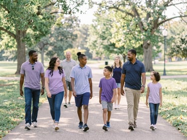 Candid wide shot of a diverse group of families walking along a sunlit park trail in Indiana, soft natural daylight, warm editorial style, 35mm