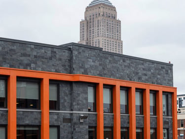 Crisp architectural view of a commercial flat roof in Manhattan with the Empire State Building softly blurred in the background, overcast daylight, industrial slate tones
