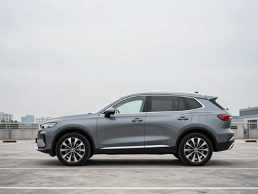 Wide three-quarter front profile of a gunmetal gray crossover SUV parked on an empty multi-level parking deck, clean overcast daylight, no people, minimal urban skyline visible in background
