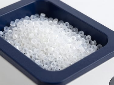 Close-up of raw plastic pellets inside a high-end spectrophotometer tray, crisp studio lighting, deep navy tones, landscape aspect