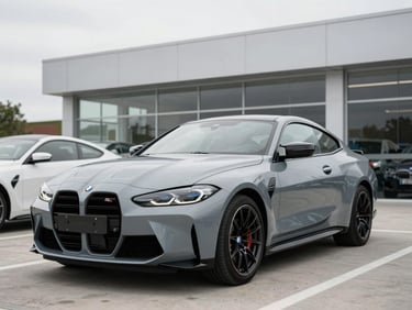 Three-quarter front angle of a metallic grey 2023 BMW M4 parked in a clean modern dealership bay, bright daylight, 50mm lens