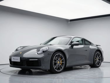 Sleek dark grey Porsche coupe in a modern high-contrast studio backdrop, crisp daylight strobes