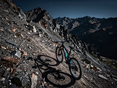 Cinematic wide-angle mountain bike POV looking down a razor-sharp alpine ridge, dramatic low-light with neon rims on the bike wheels, gritty action shot