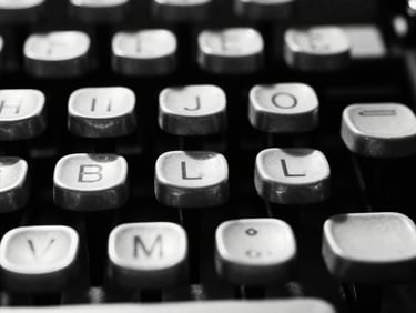 Extreme macro close-up of analog typewriter keys, stark high contrast lighting, deep shadows, 35mm film